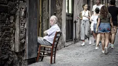 Uomo seduto su sedia all'ingresso della porta